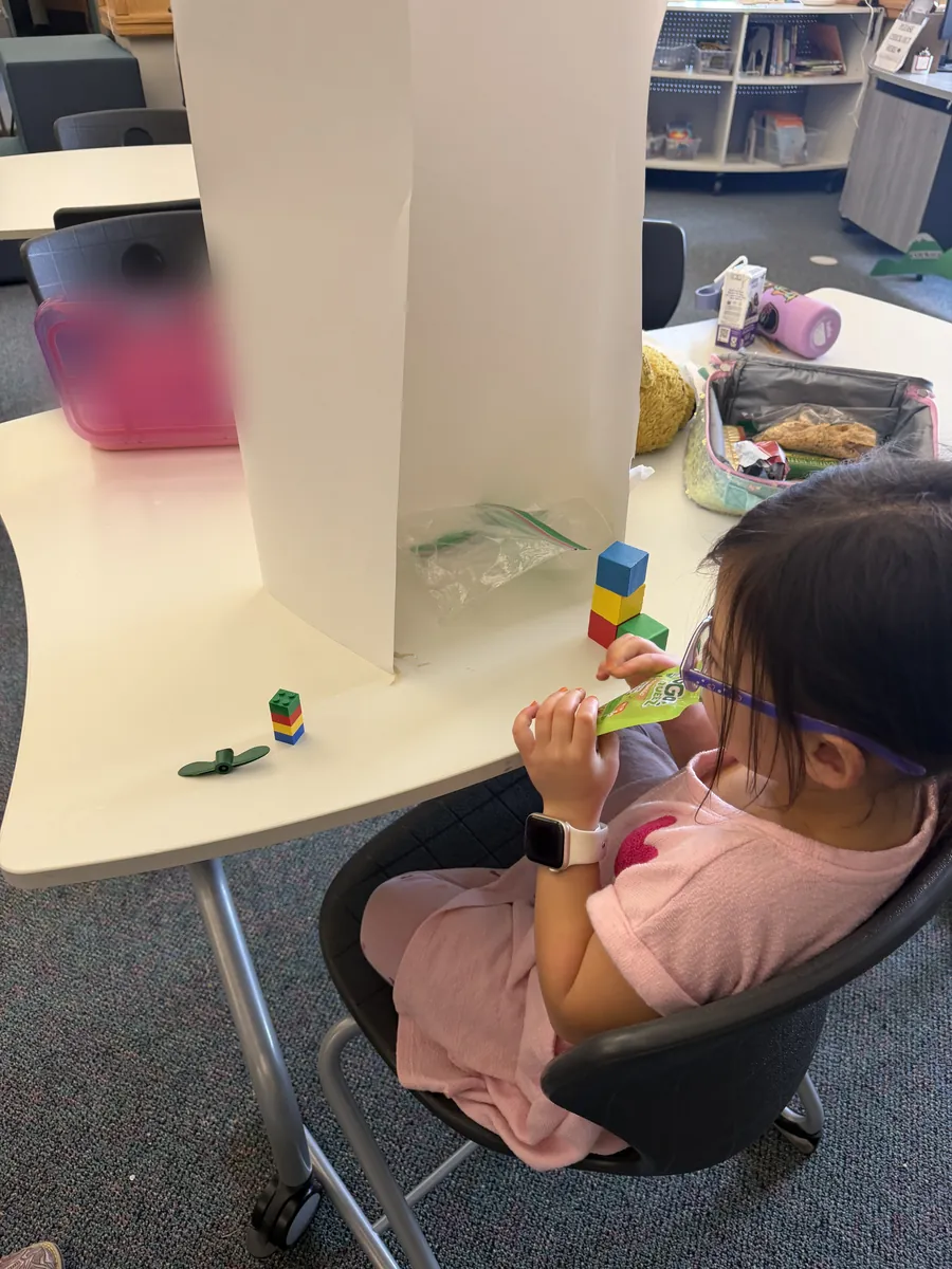 A finished block tower next to the wall, with the robot taking a snack break